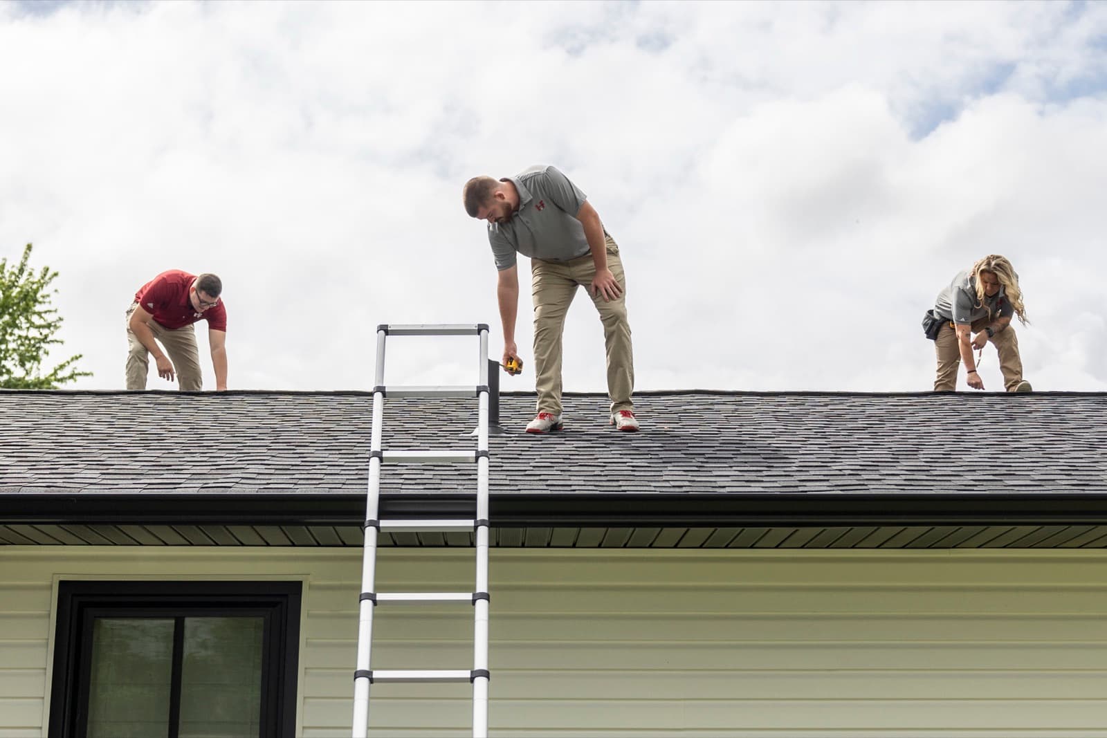 H&F inspectors on a residential roof checking the shingles during a free inspection
